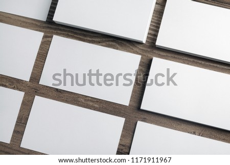 Blank white business cards on wooden background. Mockup for branding identity. Template for graphic designers portfolios.