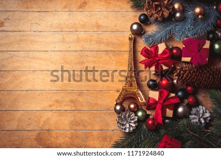 Eiffel tower souvenir with Christmas decoration on wooden table. Above view in old color style