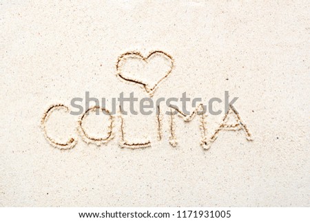 Handwriting words "Colima" on sand of beach