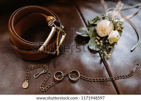 Wedding accessories. Groom accessories. Wedding details. Closeup of elegant stylish brown male shoes. Preparation for wedding concept. Horizontal photo. Wedding rings made of gold. Close-up.