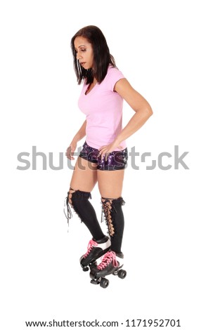 A beautiful young woman in shorts standing with her roller skates and
knee high sooks, isolated for white background
