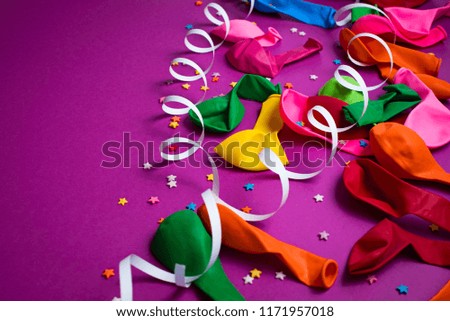 Festive background of purple material colorful balloons streamers confetti. Top view flat lay copy space