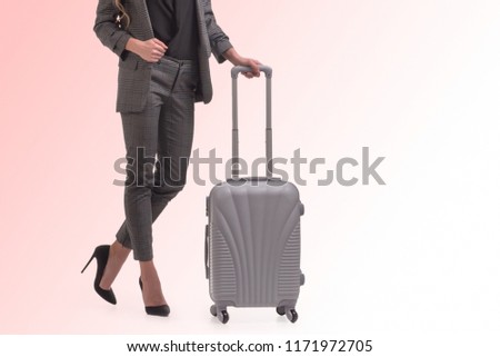 woman with a suitcase on a pink background
