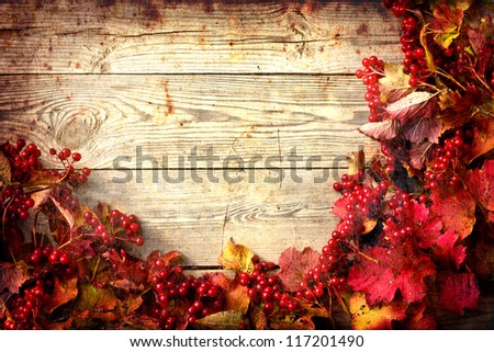 Vintage Autumn border from ashberry and and fallen leaves on old wooden table/Thanksgiving day concept/