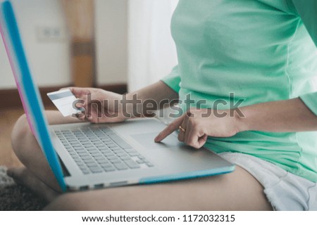 Young Asian woman using laptop computer touchpad for online shopping on weekend. Online banking and business concept with photo filter effect