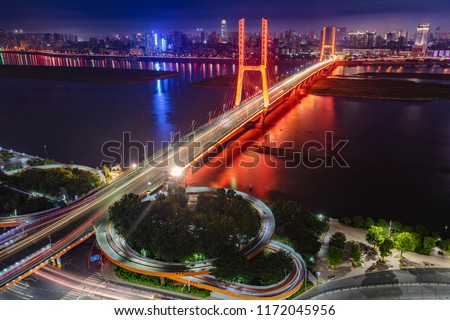 The Bayi Bridge in Nanchang, China, crosses the Ganjiang River, the beautiful city night scene, and the Shanghai city scenery background.(Chinese character translation: Bayi Bridge)