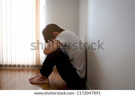 Man sitting in the corner of the room strained unhappy.Health and medical concepts Royalty-Free Stock Photo #1172047891