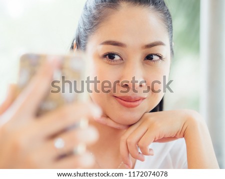 Asian woman is taking selfie photo.