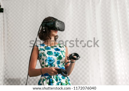 Girl in dress plays in virtual reality