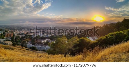 Panoramic view from Grizzly Peak in Berkeley Hills onto Berkley, Oakland and San Francisco with Karl the fog enveloping the city at sunset Royalty-Free Stock Photo #1172079796