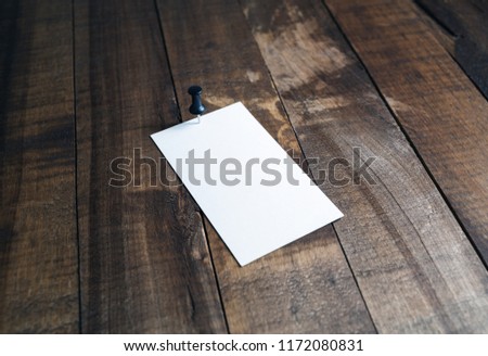 Blank white business card on wood table background. Selective focus