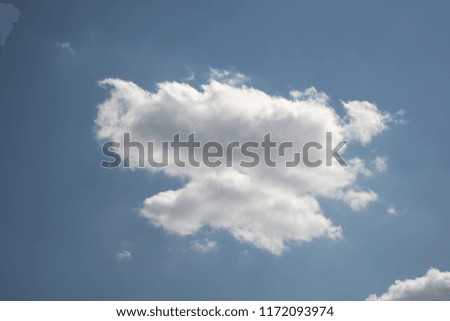 One cloud hangs in the beautiful sky at horizon level in good Sunny weather
