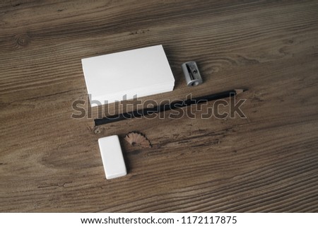 Photo of blank stationery set. Business cards, pencil, eraser and sharpener on wooden table background. Responsive design template.