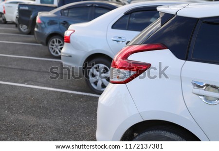 Closeup of rear side of white car park in parking area with natural background in the evening of sunny day. Royalty-Free Stock Photo #1172137381