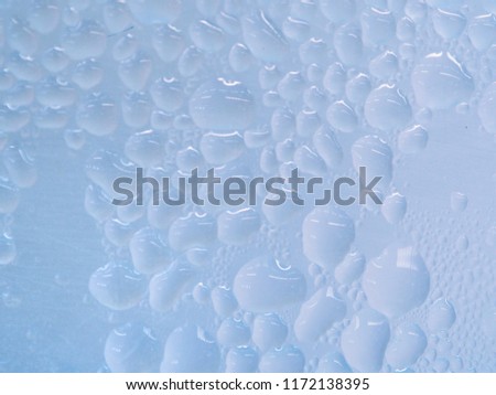 Close up blue water drops, detail of blue surface water-repellent on glass for background.