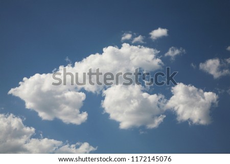 In the blue sky the wind carries the beautiful clouds of bright white