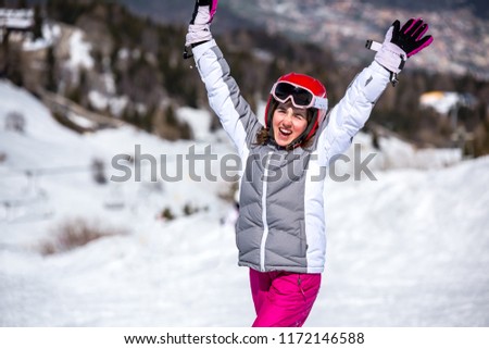 Happy little girl on the ski slopes playing with snow
