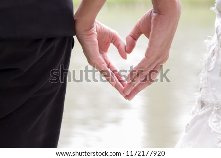 Groom and bride make a symbolic of heart by hands to show love and romantic Royalty-Free Stock Photo #1172177920