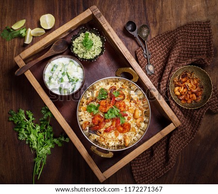Tasty and delicious prawns biryani in wooden tray beautifully arranged