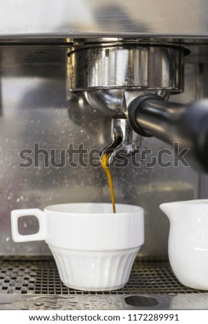A coffee machine prepares two espresso in two glass cups in a cafe. The work of the coffee machine. Culture of coffee making in the city