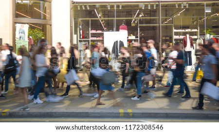 Motion blurred anonymous crowds of people on busy shopping street during a weekend  Royalty-Free Stock Photo #1172308546