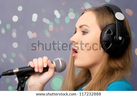 Profile of girl singing song and recording in music  studio