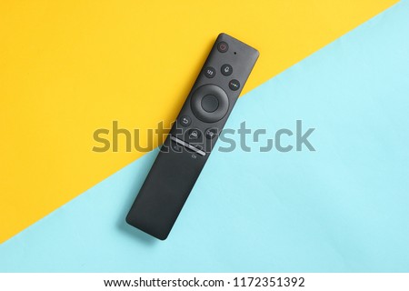 A modern TV remote control on pastel background. Top view, minimalism
 Royalty-Free Stock Photo #1172351392