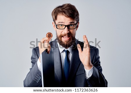 business man in a suit he keeps a coin in the hand of a crypto currency                           