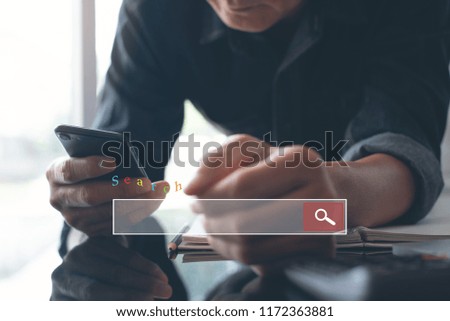 Browsing internet information search engine via mobile smart phone. Man hand using electronics device and laptop computer, e learning at modern office