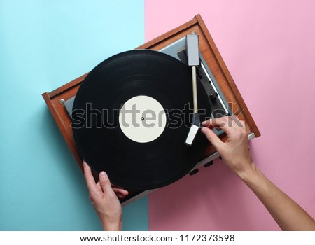 Female hands  use retro vinyl player on a blue pink pastel background. DJ. Top View
 Royalty-Free Stock Photo #1172373598