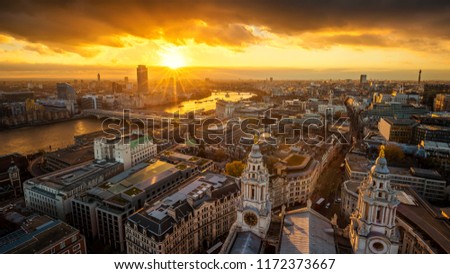 London, England - Aerial panoramic skyline view of London taken from top of St.Paul's Cathedral at sunset with River Thames, beautiful golden sky and clouds