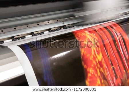 Massive print head processing an oversized glossy color sample before initiating customer orders. Royalty-Free Stock Photo #1172380801