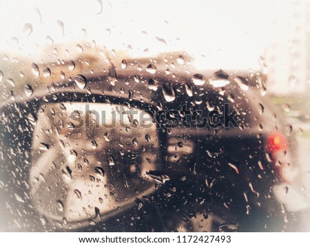 a blurry with heavy rain. A rain storm, raindrops splatter on the windshield  and car window