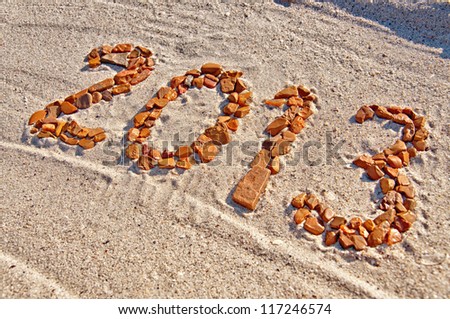 2013 inscription made from pebbles lying on sand surface Royalty-Free Stock Photo #117246574