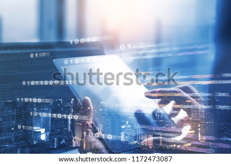 Business and technology, software development, IoT concept. Double exposure, man programmer, software developer working on digital tablet and smart city with binary, html computer code on screen