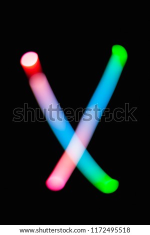 Letter X. Glowing letters on dark background. Abstract light painting at night. Creative artistic colorful bokeh. New Year. Use it for build you own design for book cover, CD, poster or post card.