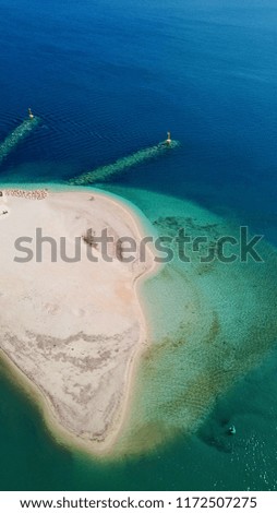 Aerial drone bird's eye view photo of tropical sandy beach with sun beds and emerald clear waters