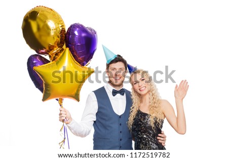 people, celebration and holidays concept - happy couple with party caps and balloons