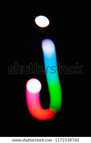 Letter J. Glowing letters on dark background. Abstract light painting at night. Creative artistic colorful bokeh. New Year. Use it for build you own design for book cover, CD, poster or post card.