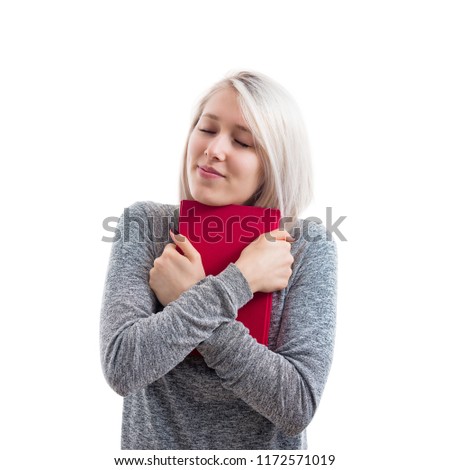 Pretty student woman holding a red book to chest with closed eyes. A warm hug to knowledge isolated over white background.