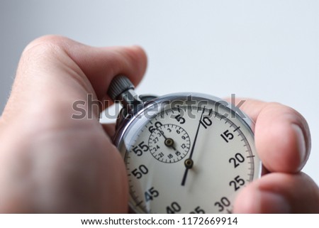Close-up of an isolated hand presses the stopwatch start button in the sport, measurements, metrology Royalty-Free Stock Photo #1172669914