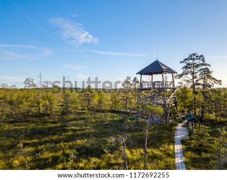 Moody Drone Photo of Colorful Moorland in Early Summer Sunrise with a Wooden Path Through it and a Watchtower in the Corner