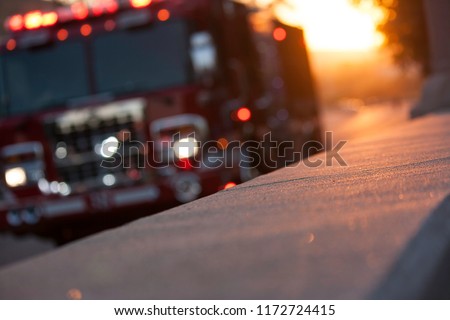 Fire truck pulls up to the scene of an accident at sunset Royalty-Free Stock Photo #1172724415