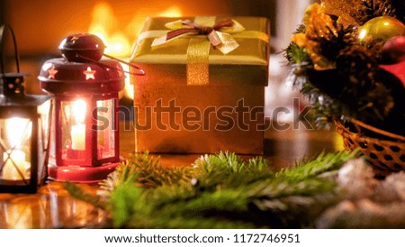 CLoseup photo of beautiful Christmas decorations and ornaments against burning fireplace