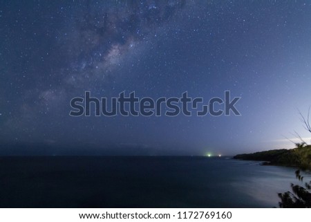 Milky Way from southern hemisphere with dark blue night sky in background and ocean coast in foreground