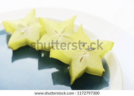 Ñarambola fruit (starfruit) slices on plate closeup 
