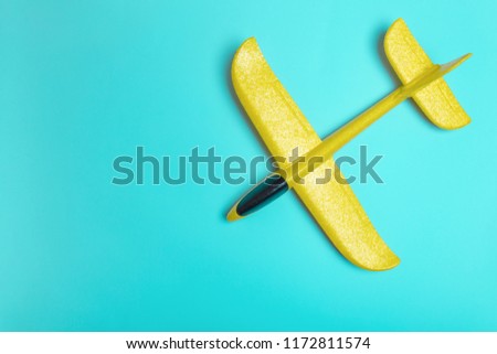 yellow model of passenger plane on blue background.