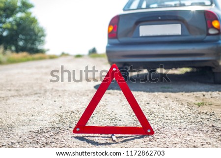 Broken car concept, breakdown triangle on road. Sign of emergency stop car on the road. Broken down car dangerously parked awaiting recovery services