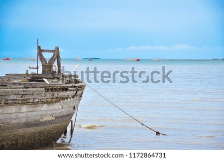 An old shipwreck boat abandoned stand on beach or Shipwrecked off the coast.
Abandoned old vintage wooden fishing boat on beach.