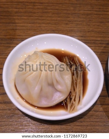 Close-up of Xiao long bao (soup-filled dumpling) ,
in Black Chinese vinegar dipping sauce ,
Small body, large filling, juicy, fresh, thin skin. Royalty-Free Stock Photo #1172869723